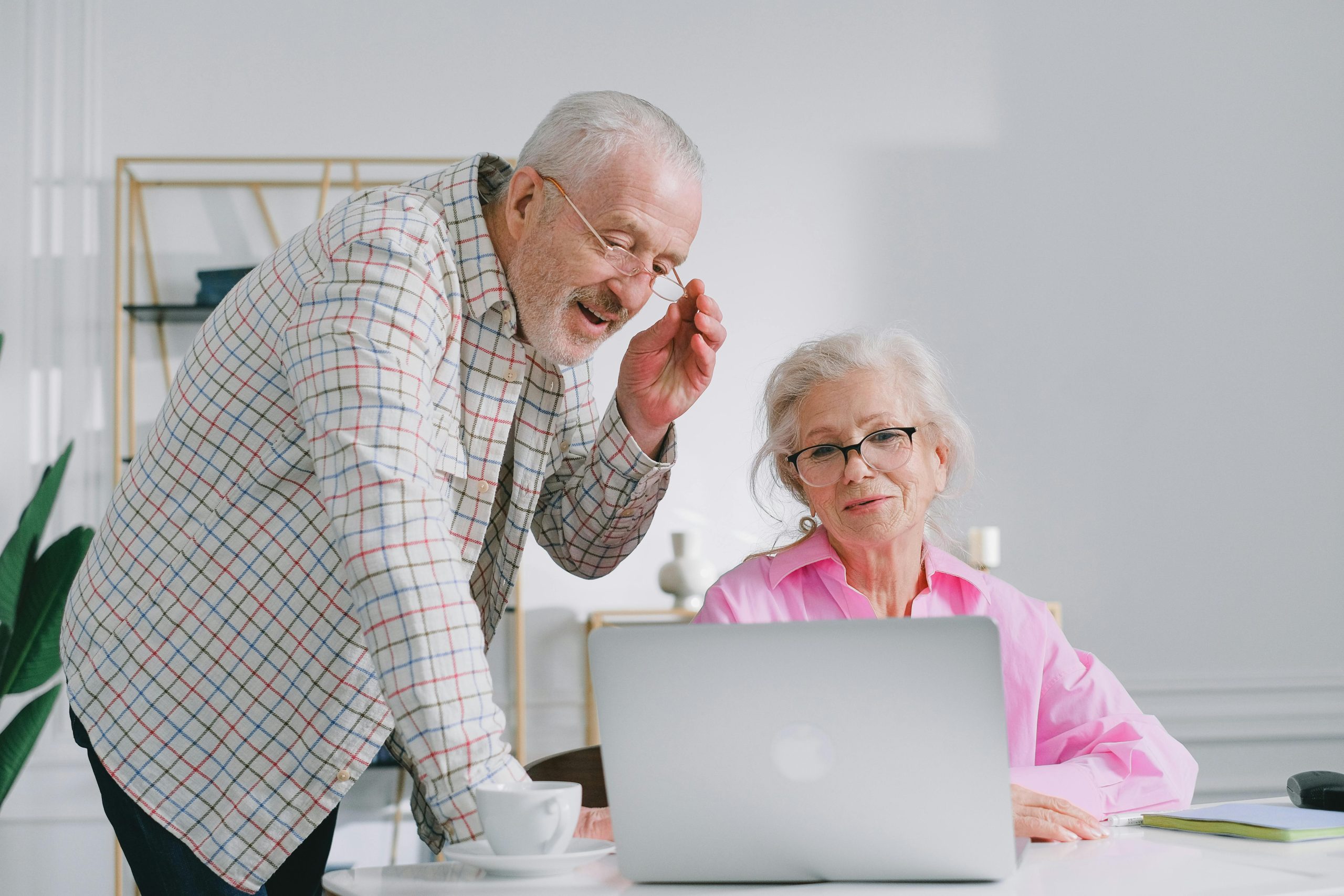 Una mujer y un hombre, de unos 65 años mirando un ordenador portátil